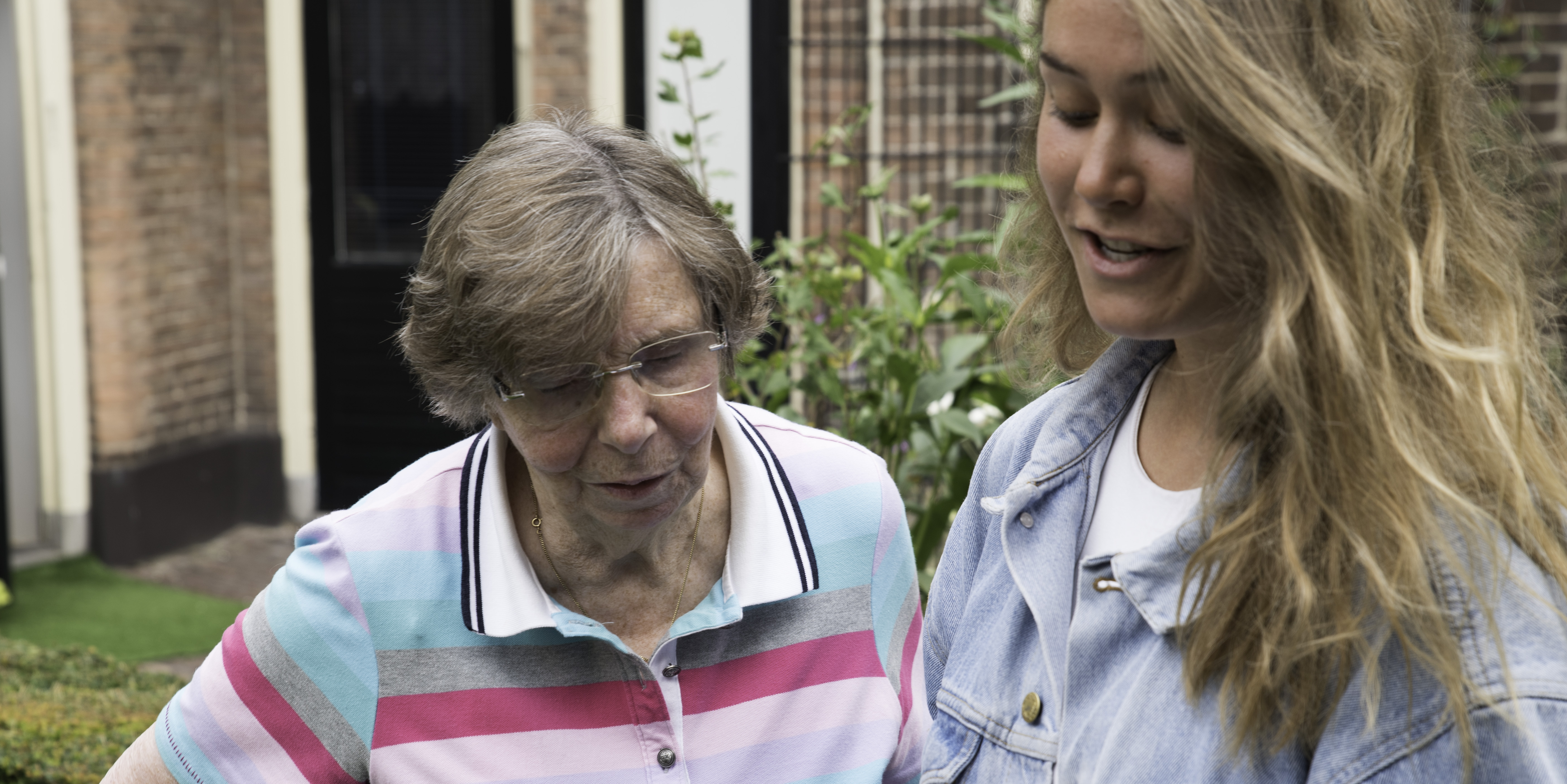 Oudere vrouw en jongere vrouw staan samen buiten