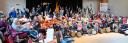 Een grote groep kinderen maken samen muziek met grote trommels