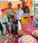 Drie vrouwen staan achter een kraam met ranja